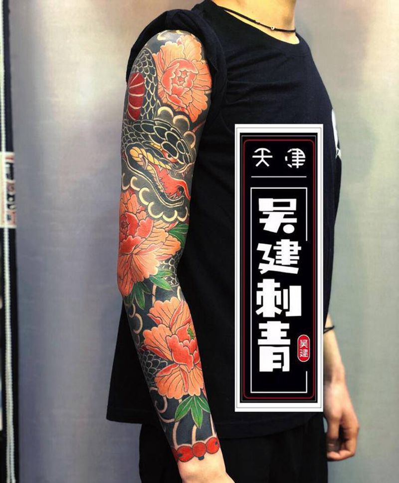 蟒戏牡丹花臂纹身图片_手臂老传统纹身图案