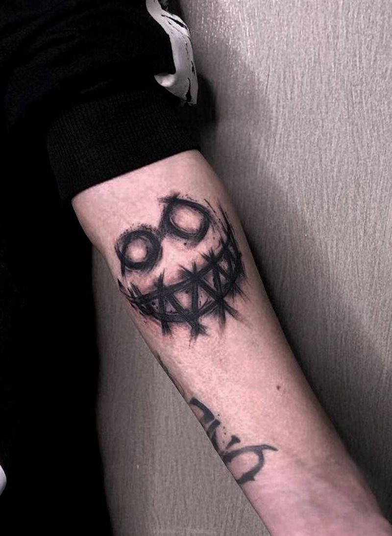 恶魔笑脸纹身图片_手臂纹身图案