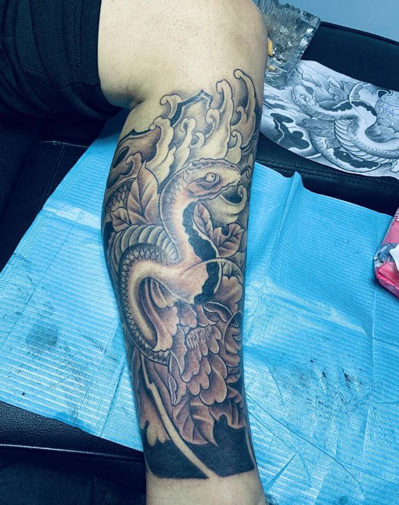 蛇戏牡丹纹身图片_腿部新传统纹身图案