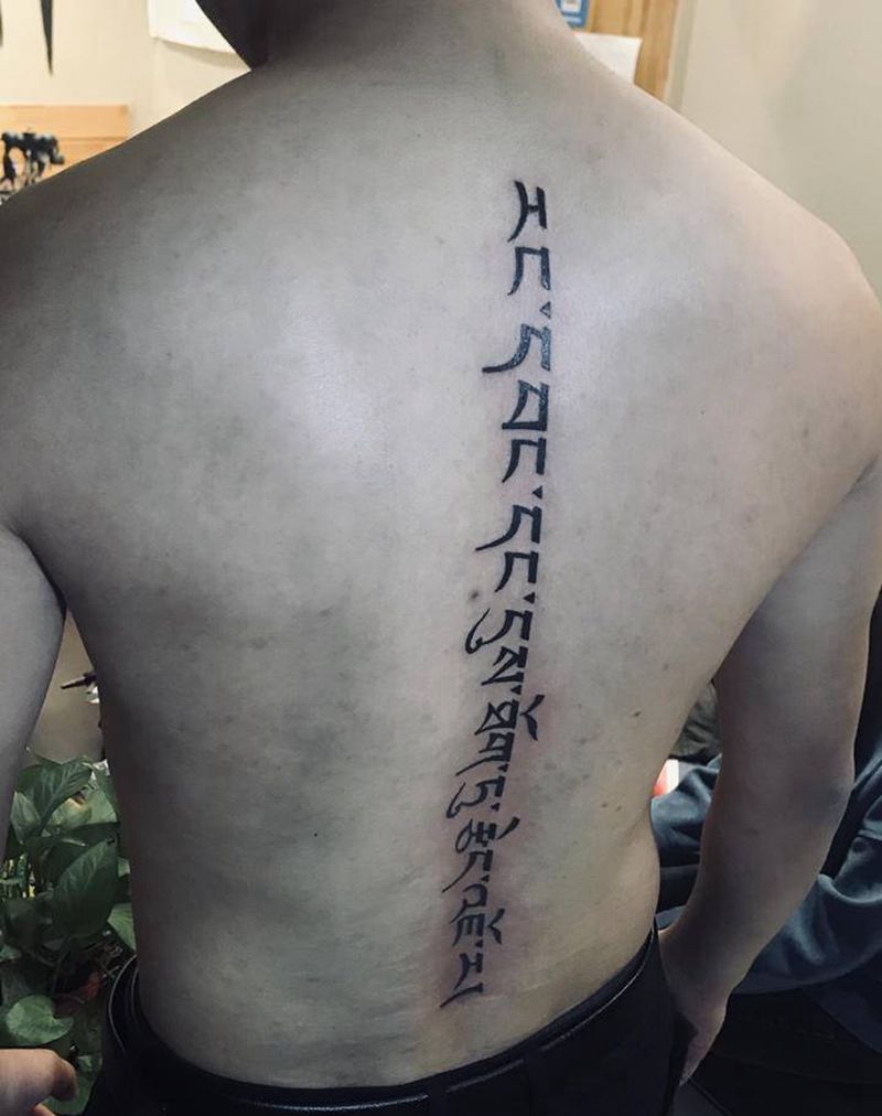 脊椎藏文纹身图片_背部图腾花体字纹身图案