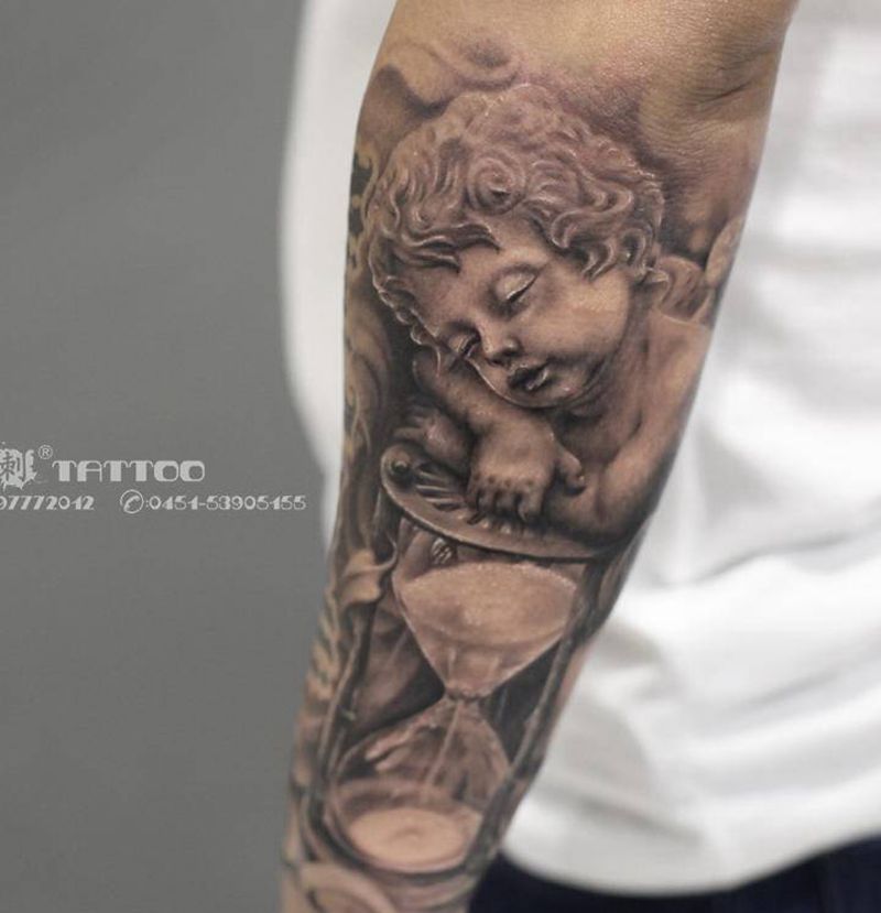 执着于理想，纯粹于当下纹身图片_手臂欧美写实天使沙漏欧美纹身图案