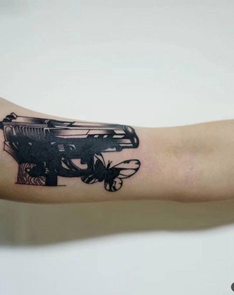 枪与蝴蝶（覆盖）纹身图片_手臂几何黑色工业枪蝴蝶纹身图案