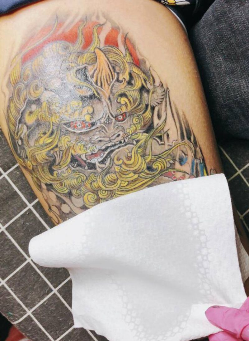 唐狮戏绣球纹身图片_腿部新传统唐狮牡丹纹身图案