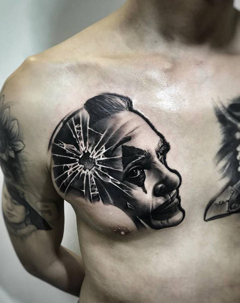 致命的微笑纹身图片_胸部肩部欧美写实小丑黑灰写实纹申坤纹身图案