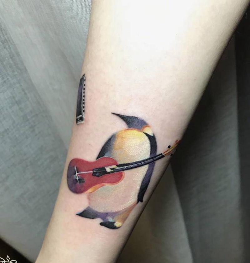 演唱家纹身图片_手臂欧美写实企鹅口琴纹身图案