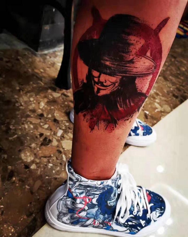 V字仇杀队纹身图片_腿部水墨点刺人物纹身图案