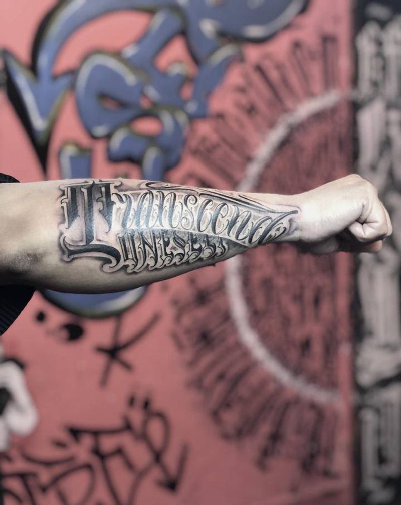 英文意思：超越自我纹身图片_手臂花体字纹身图案